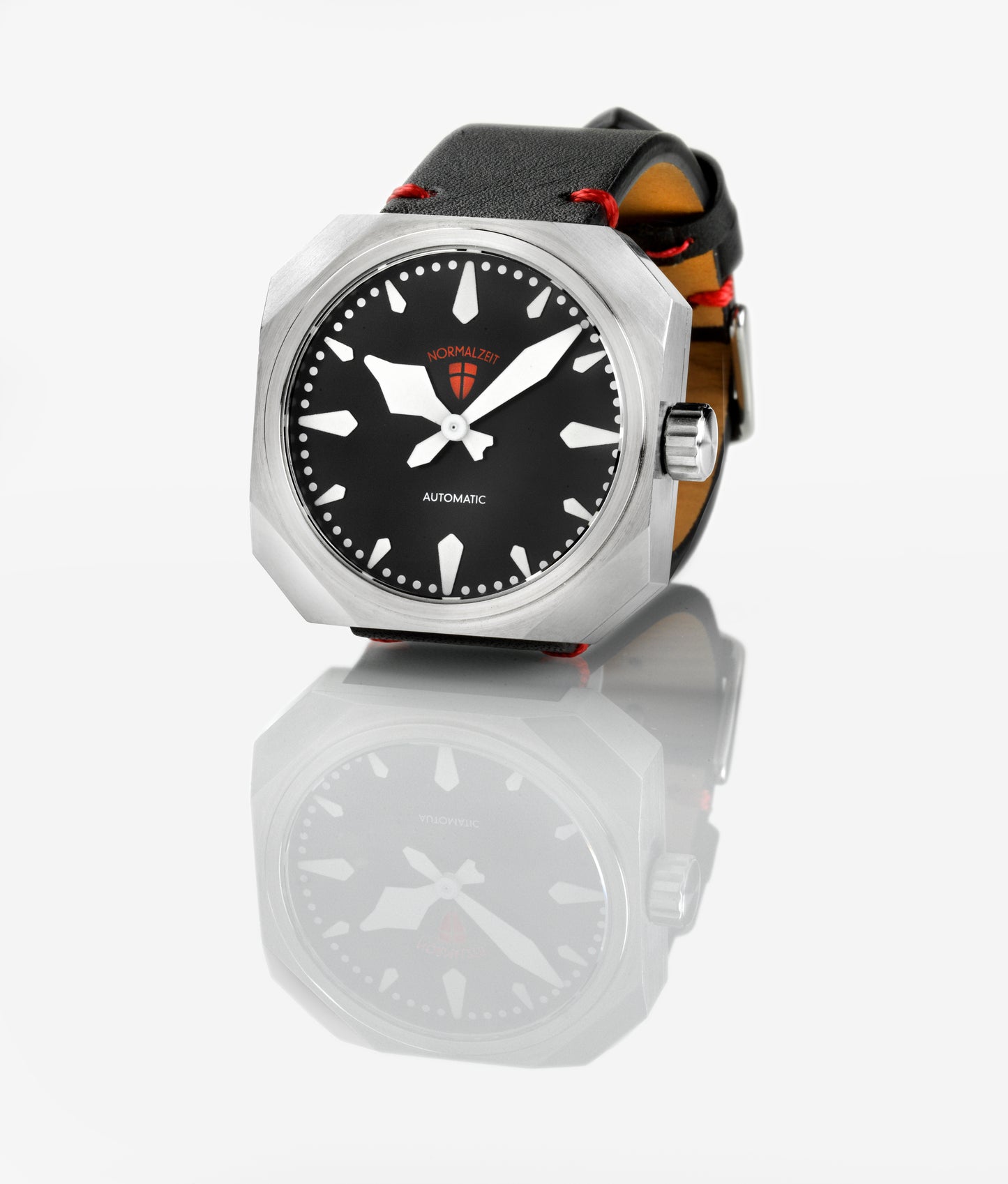 Normalzeit Der Grenadier automatic watch three-quarter view showing matte black dial, Super Luminova markers, brushed octagonal case, and black leather Vienna Strap with red stitching